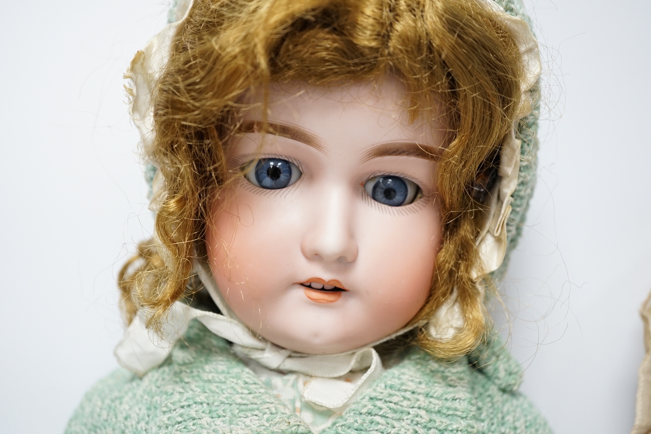 An AM390 bisque head doll, 63cm good condition, and an AM390, missing two fingers and wear on other hand, 58cm